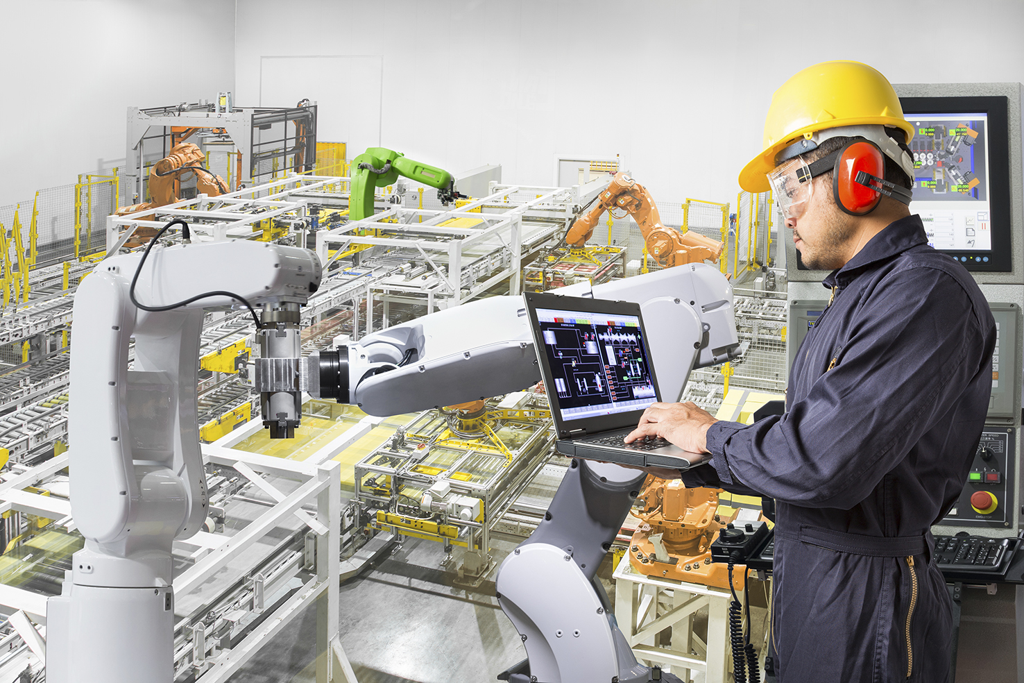 Engineer using laptop computer for maintenance automatic robotic hand machine tool at industrial manufacture factory